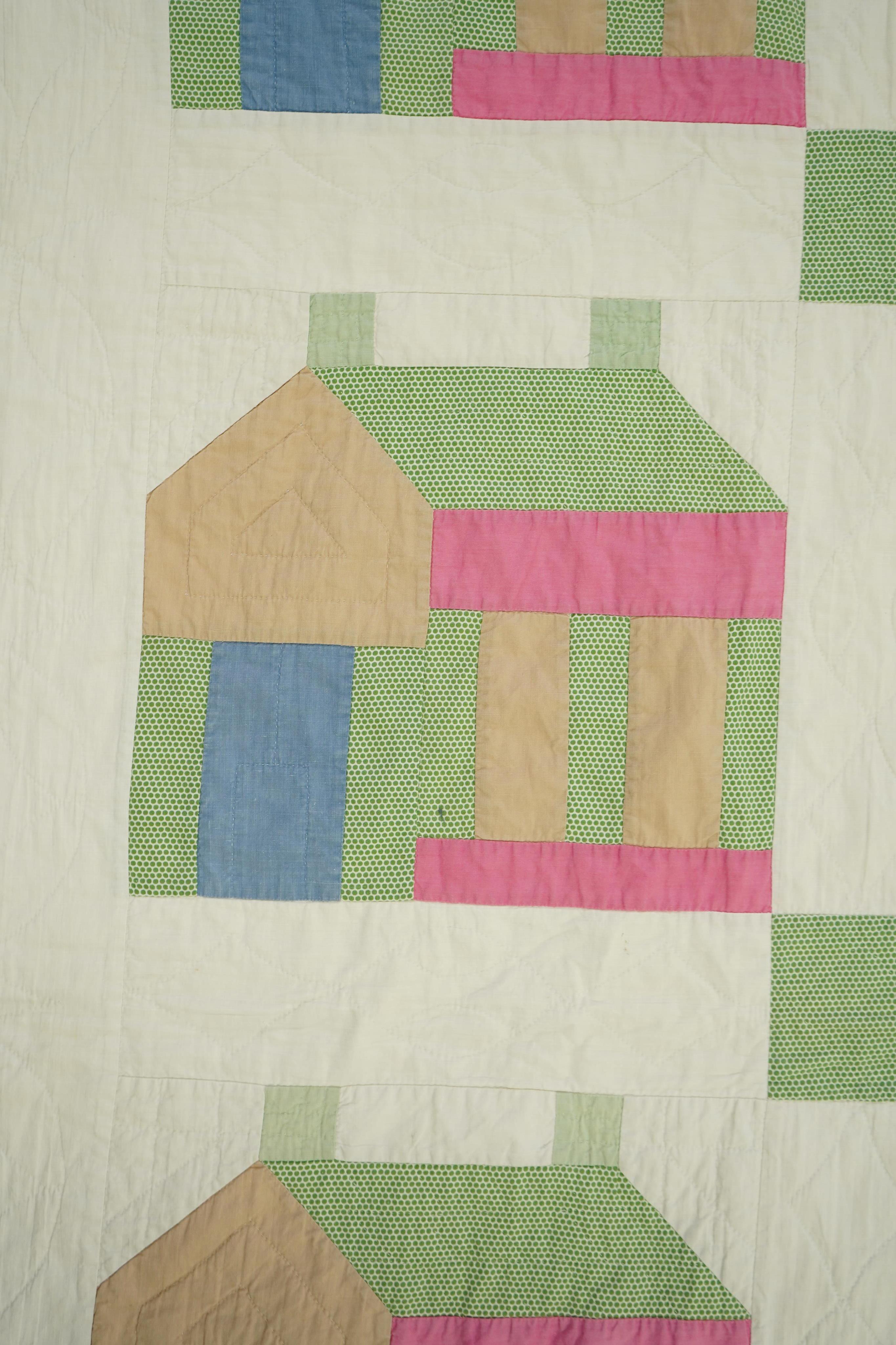 A 1930’s American quilt from Vermont. Quilted in large patchwork ‘house’ motifs, repeating the same four colours in each motif against a plain white background. The reverse a plain white quilted cotton . The quilt hand p